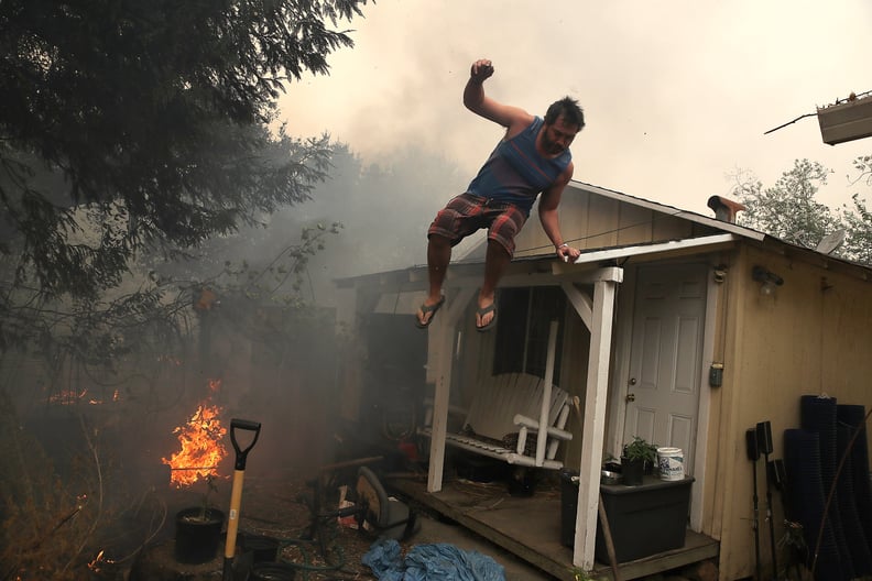 A man scrambles to save his home from flames.