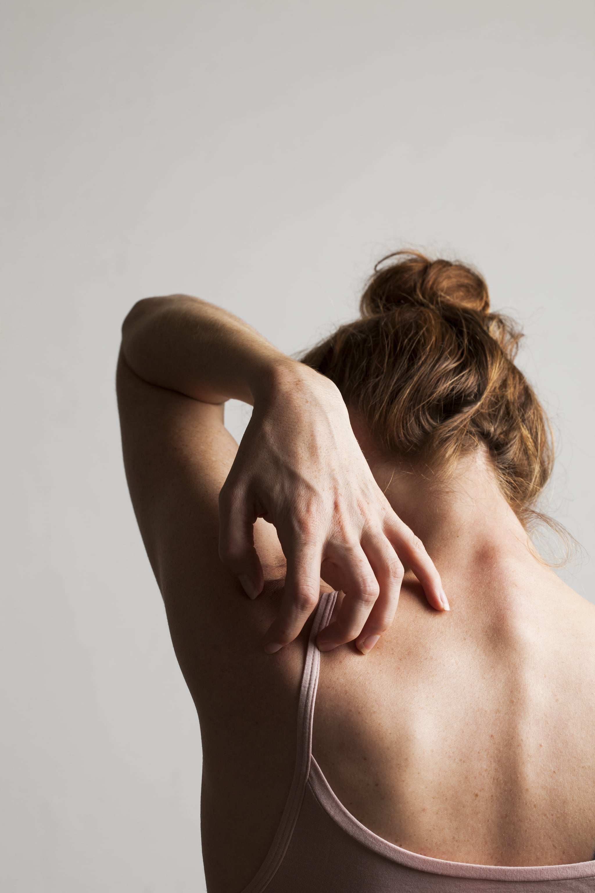  Woman scratching her itchy back.