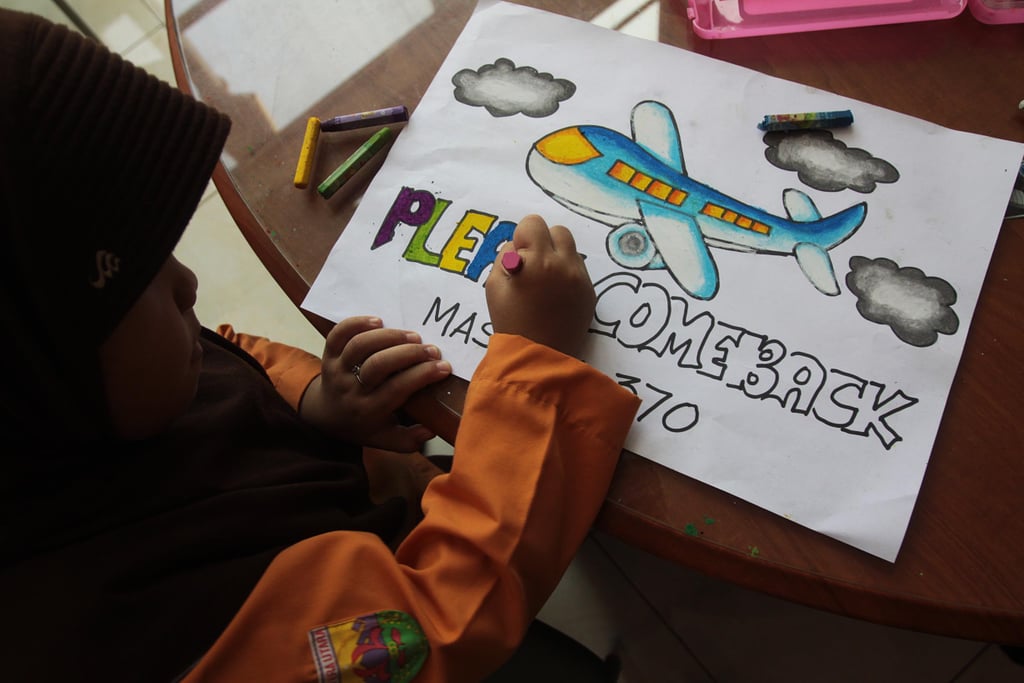 An Indonesian child colored in letters on a poster with a hopeful message on Saturday.