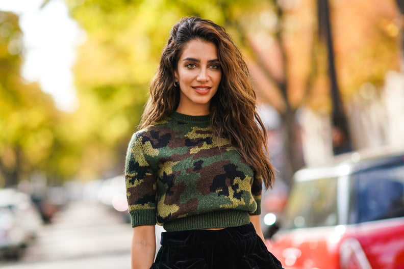 PARIS, FRANCE - OCTOBER 01: Jessica Kahawaty wears a military camouflage print pullover, black pants, a black leather bag, outside Miu Miu, during Paris Fashion Week - Womenswear Spring Summer 2020, on October 01, 2019 in Paris, France. (Photo by Edward B