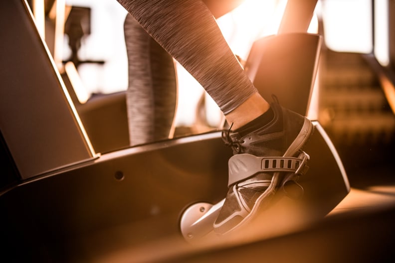 Close up of athletic person exercising on exercise bike in a gym.