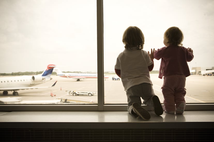 Two Children Excitedly Watch as Planes Land at the Airport