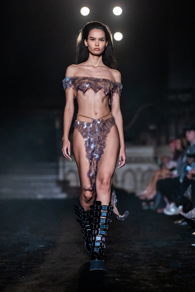 Ahead of his buzzy Paris Fashion Week debut, Cowan hosted an exclusive preview of look 50 from his spring 2024 show, a two-piece set made in part using upcycled plastic from empty Core Hydration bottles. The ensemble includes an off-the-shoulder crop top and a hip-baring, low-rise skirt.
"Paillettes and sequins have always been a big part of my brand's history, and we've always really tried our best to find suppliers who do recycled plastic sequins," he says. "But then I saw this article saying apparently, a bunch of those suppliers lie and they say it's recycled, but it's not." And so, Cowan set out to find an alternative. 
"I was like, we should make paillettes out of these bottles," he recalls. "Because I cut one off and I love that if you cut the circle, it's got a natural curve to it that gives just more of a feathery feel to the embellishment."
Reusing materials is important to Cowan, whose father regularly brought environmental issues to their everyday conversations. "My father was a glaciologist, someone who studies glaciers," he shares. "Environmental impact was a huge, huge topic of my entire upbringing all the time. I always want to be as sustainable as possible."
In addition to minimizing his brand's environmental impact, Cowan is focussed on evolving as a designer without losing the essence of his eponymous label. "What I love is our customers, when I see them wearing our clothes, they're always laughing and smiling and just doing poses," he says. "And I love that it gives that kind of power to whoever's wearing it. I would never want to leave that energy no matter what heights the brand grows to — I always want to be a joyful brand."