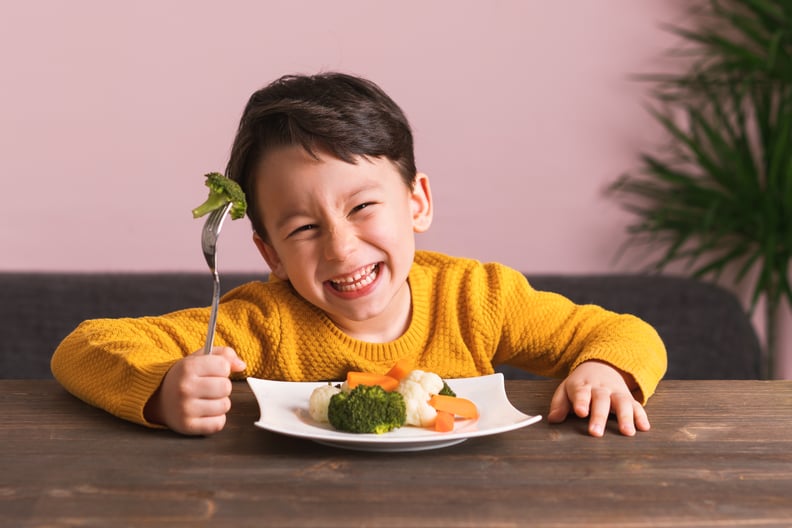 Child is eating vegetables. He is very happy.