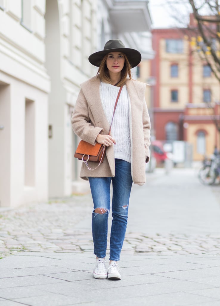 With a White Jumper, a Cream-Coloured Coat, and Distressed Denim