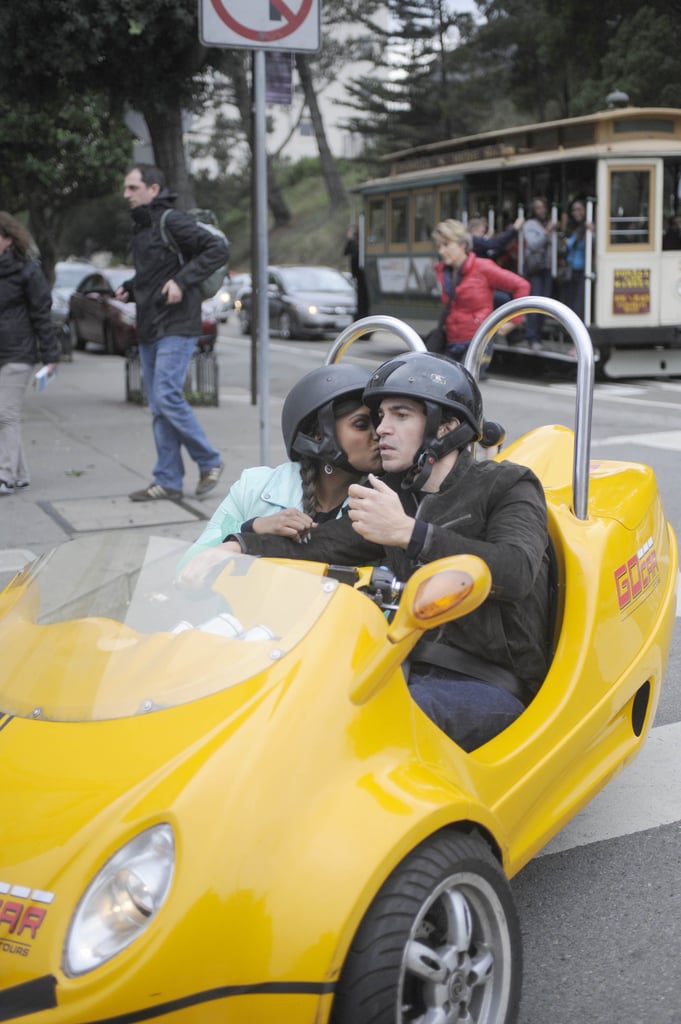 Mindy gives Danny a kiss while riding around in a little GoCar.