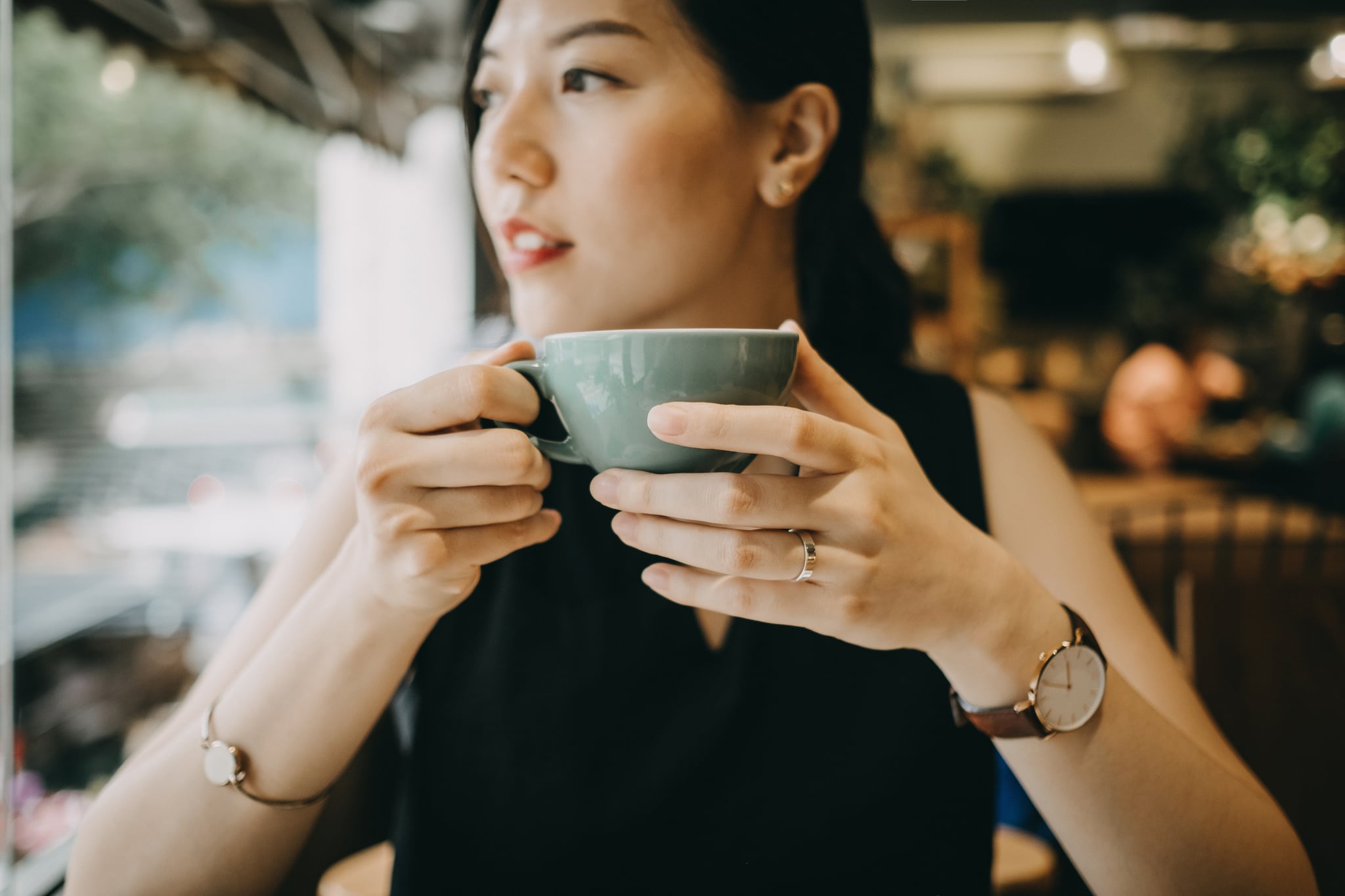 Beautiful young woman enjoying coffee in cafe