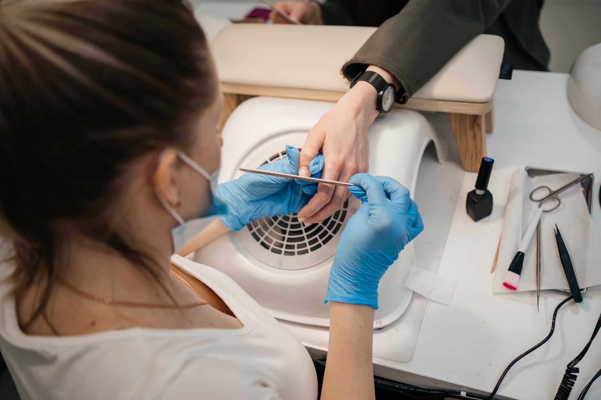 Manicurist works with client's nails
