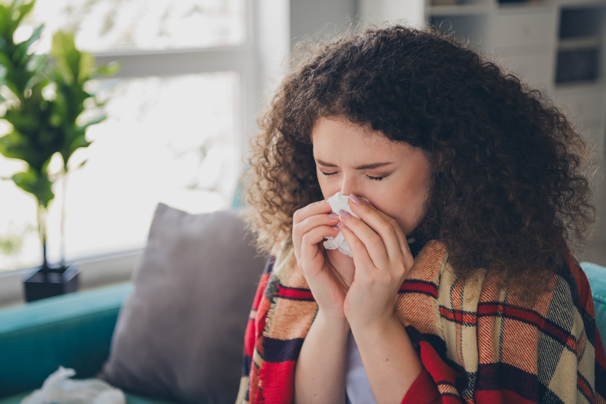 Woman blowing her nose wondering how long a cold is contagious.