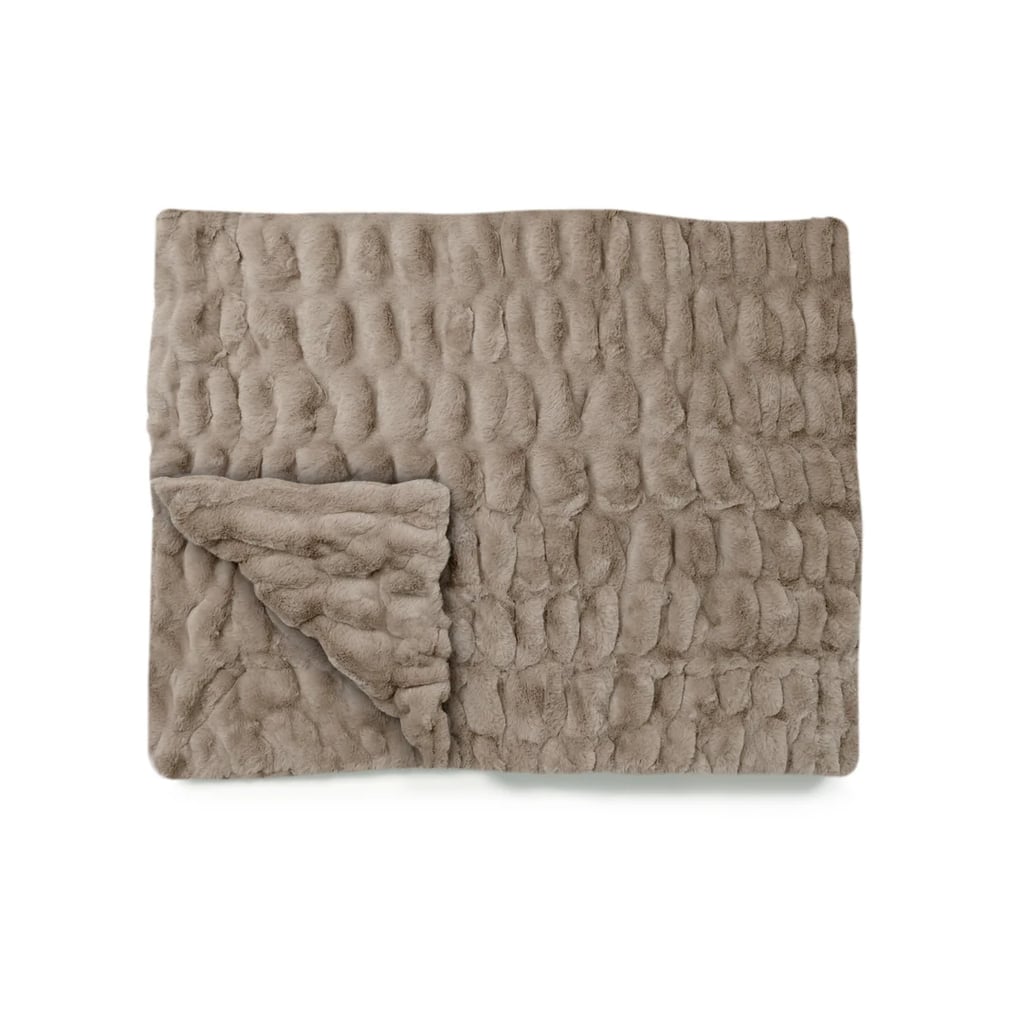 Lola Blanket in Desert Dune ($275)

There's a reason celebrities like Selena Gomez, Kourtney Kardashian, and Alix Earle can't stop raving about Lola Blankets; they're that comfortable. Available in everything from baby and travel sizes to extra-large, there's one to fit the bed, couch, or even carry-on bag. Cozy enough for anyone, this is a gift you know they'll actually use.

Editor Quote: "Dare I say this is the most comfortable blanket I've ever curled up in? And yes, I went there. It's so buttery soft that I actually look forward to slamming my laptop shut, changing into pajamas, and cocooning myself until bedtime. And even then, I drag it in with me." — Haley Lyndes, shopping staff writer