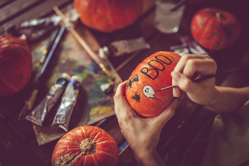 Woman painting a pumpkin for Halloween