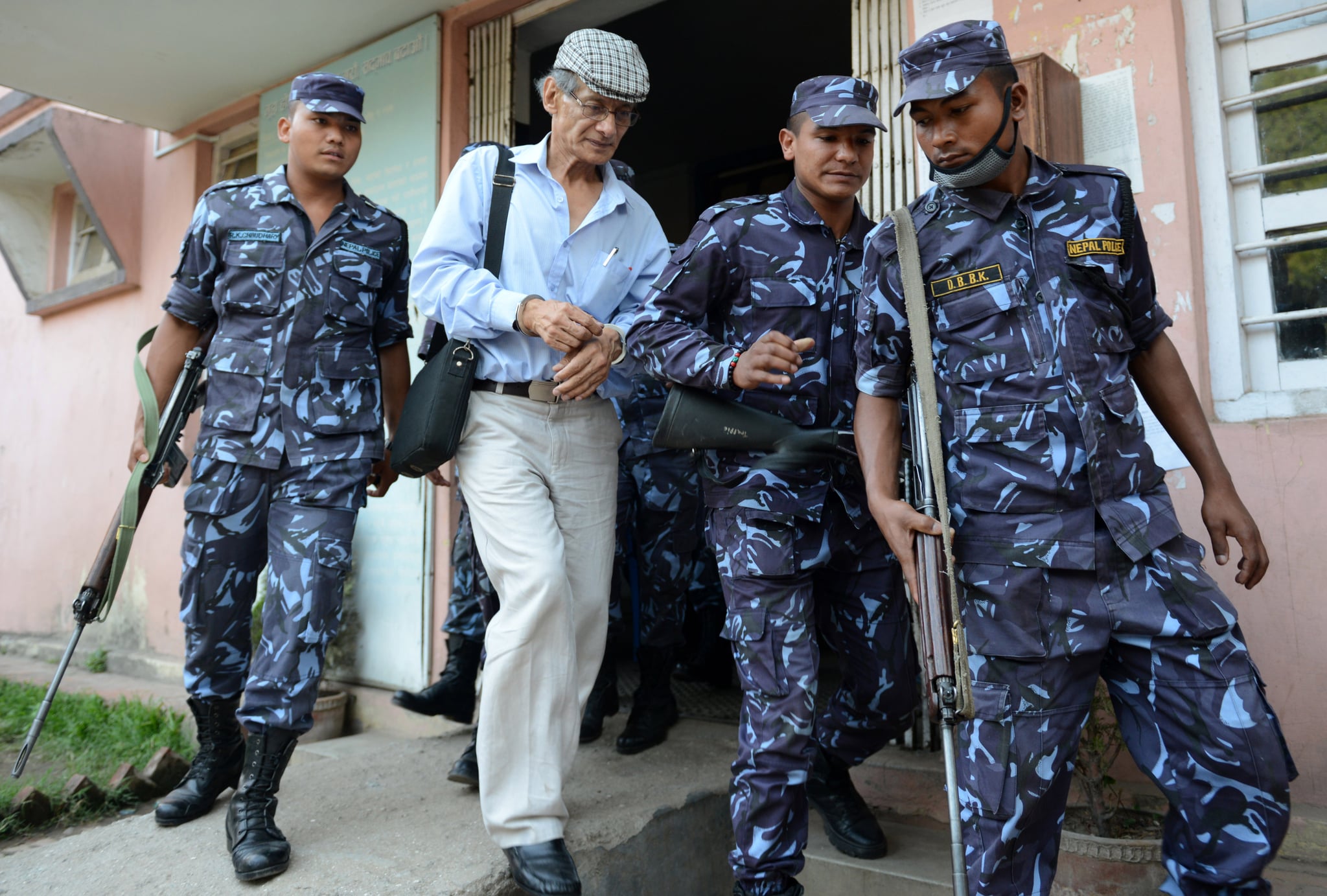 French serial killer Charles Sobhraj (2nd L) is escorted by Nepalese police to a waiting vehicle after a hearing at a district court on a case related to the murder of Canadian backpacker Laurent Ormond Carriere, in Bhaktapur on June 12, 2014. Sobhraj, a French citizen who is serving a life sentence in Nepal for the murder of an American backbacker in 1975, has been linked with a string of killings across Asia in the 1970s, earning the nickname 