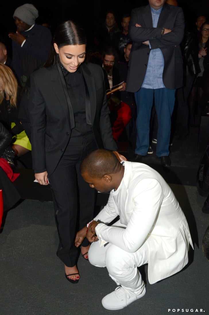 Kanye West helped Kim Kardashian with her shoe. | Kim Kardashian and