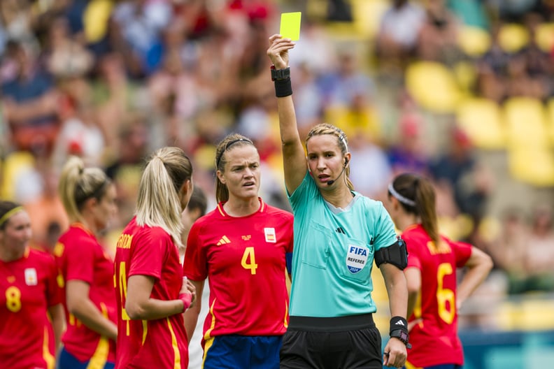 NANTES, FRANCE - JULY 25: Referee Bouchra Karboubi (R) shows a yellow card for Laia Aleixandri of Spain (L) during the Women's group C match between Spain and Japan during the Olympic Games Paris 2024 at Stade de la Beaujoire on July 25, 2024 in Nantes, F