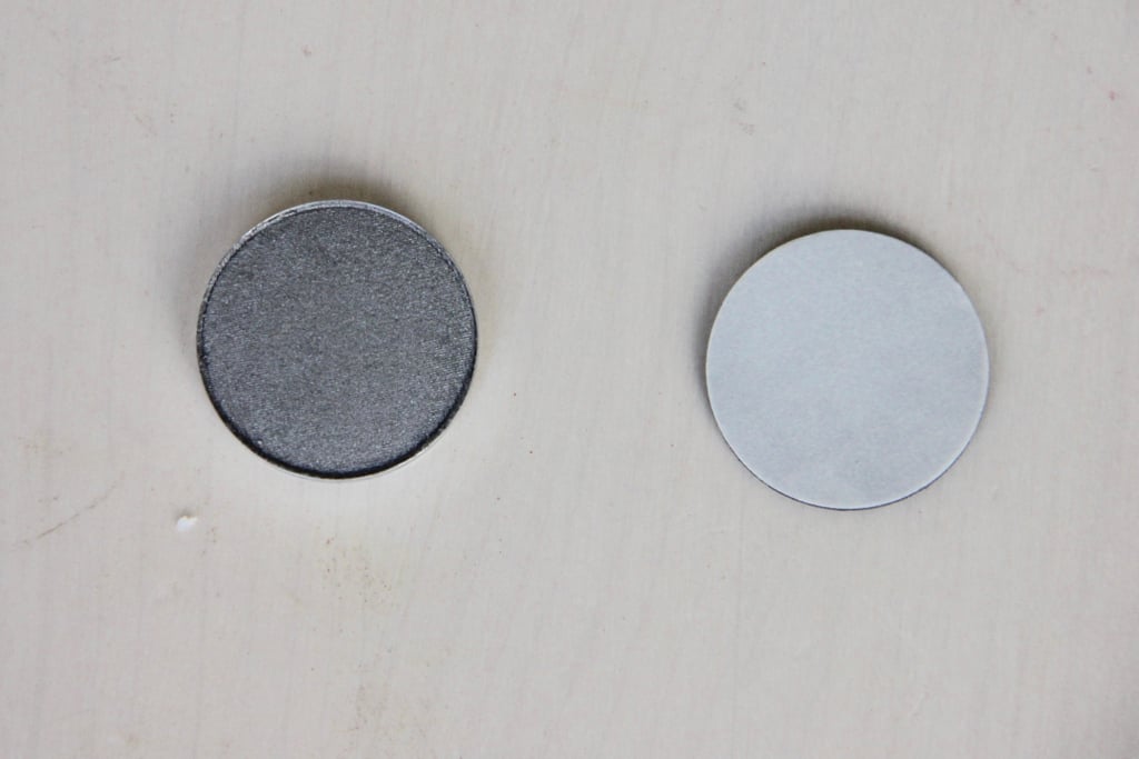 Peel the paper off of the adhesive magnet and stick it to the back of the eye shadow pan. This will allow you to use it in a magnetic palette.