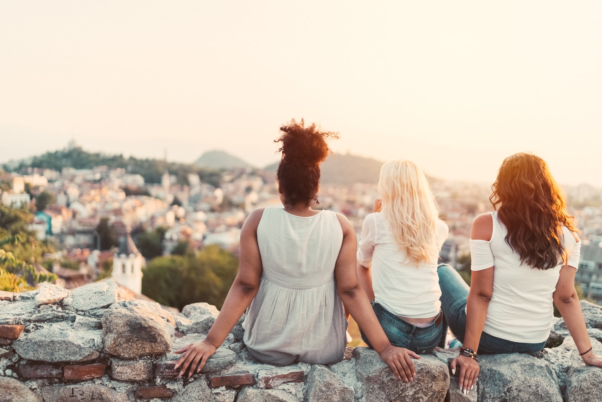 Group of friends staring the sunset from above