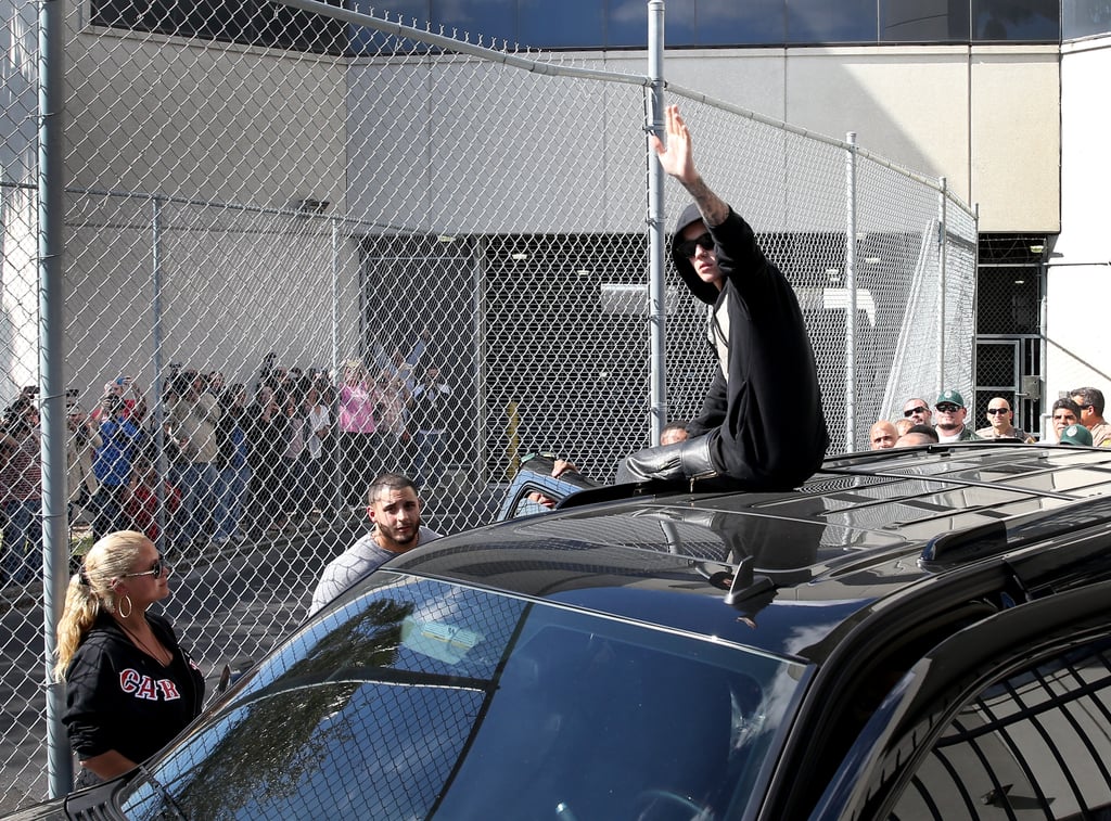 Justin Bieber left the Miami-Dade County jail in Florida on top of his black SUV while waving to gathered fans.