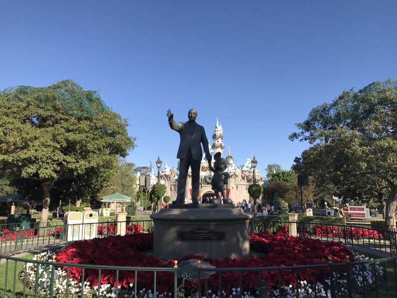 Walt and Mickey Are Surrounded by Holiday Flowers as They Greet Guests on Their Way to the Castle.
