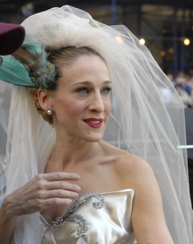 "I put a bird on my head!" Carrie goes for a sophisticated and sleek bridal beauty look with a slick updo and a pop of red on her lips.