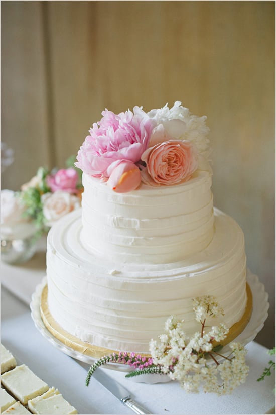 Top a buttercream-covered cake with pretty flowers, and ...