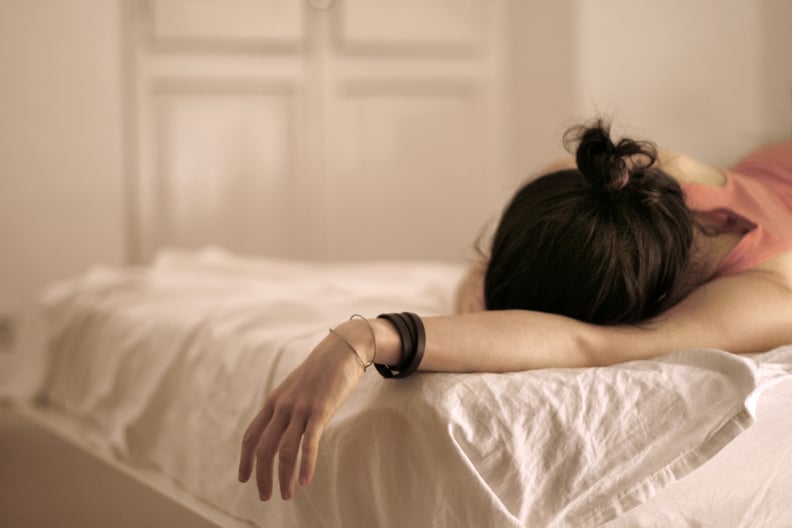 Woman lying on bed in day time.