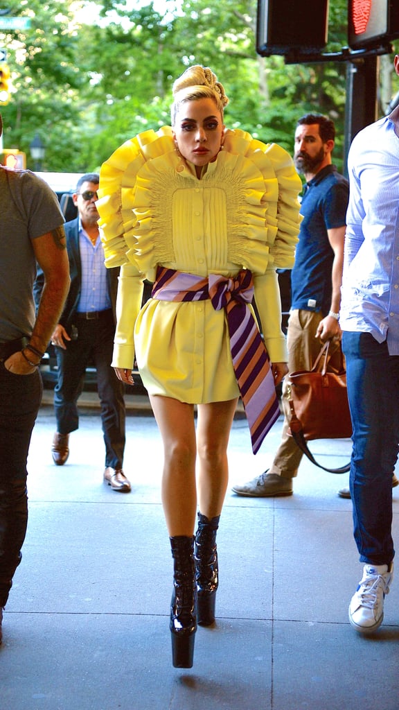 Wearing a ruffled yellow dress with a detailed belt.