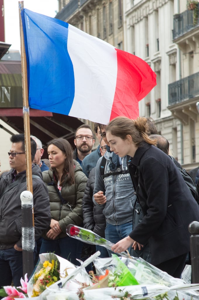 A French flag proudly waved during a minute of silence observed outside Paris's Le Carillon restaurant.