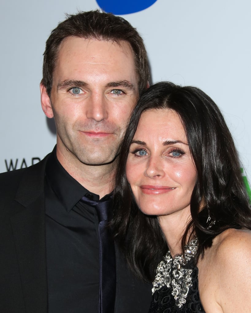 Courteney Cox stayed close to her fiancé, Johnny McDaid, at the Warner Music afterparty.