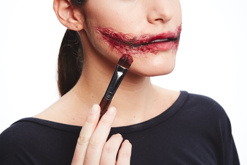 Paint on eyeshadow and red lipstick until you get the bloody effect you want. Add more foundation around the edges to help cover any tissue that doesn't blend into the skin.