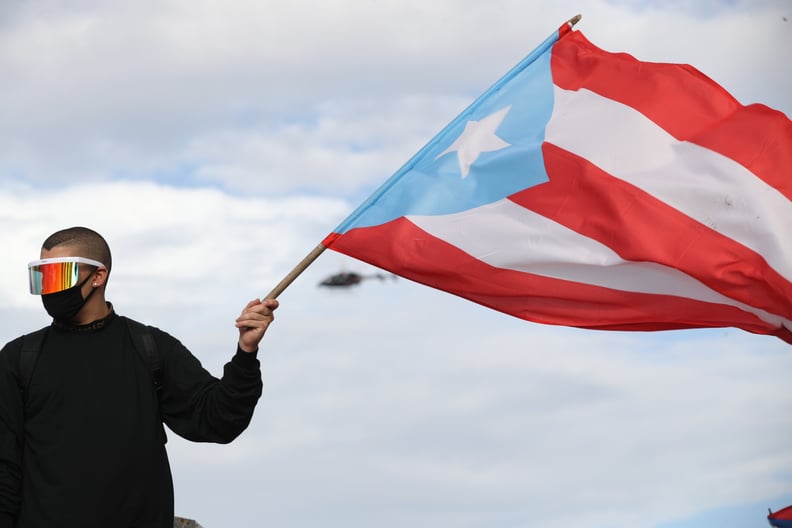 OLD SAN JUAN, PUERTO RICO - JULY 17: Reggaton singer and rapper Bad Bunny waves a Puerto Rican flag during protests against Ricardo Rossello, the Governor of Puerto Rico on July 17, 2019 in front of the Capitol Building in Old San Juan, Puerto Rico. There