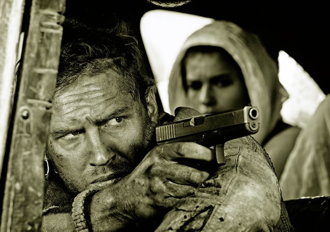 Hardy as Mad Max and Theron as Furiosa in the back.