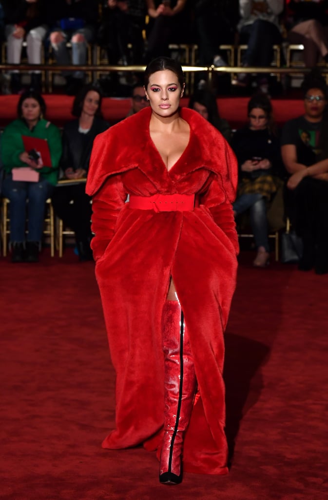 Opening Christian Siriano's show wearing a fuzzy red coat, thigh-high boots, and a red belt.