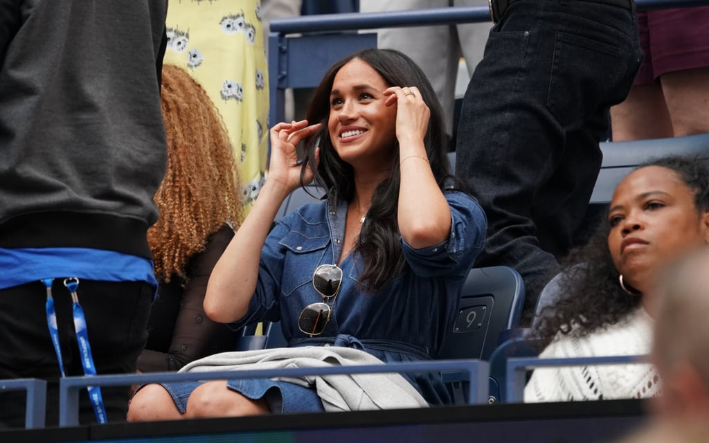 Meghan Markle is back in the US to support her BFF Serena Williams, and she looks darling in denim. The Duchess of Sussex kept things casual as she attended Saturday's match and opted for a button-down J.Crew dress with a grey J.Crew sweater and Victoria Beckham aviator sunglasses. 
Based on her past stylish picks, we know Meghan is a fan of denim although she doesn't publicly wear many pairs of blue jeans as a royal. More often, we see her in denim dresses which give her wardrobe an all-American feel. She's also a frequent J.Crew shopper, with many of her shoes, clutches, and coats coming from the brand. 
Ahead, see even more glimpses of her look and bonus points if you can guess what she and Anna Wintour are talking about. Fingers crossed it has something to do with next year's Met Gala — hey, we can dream, right?