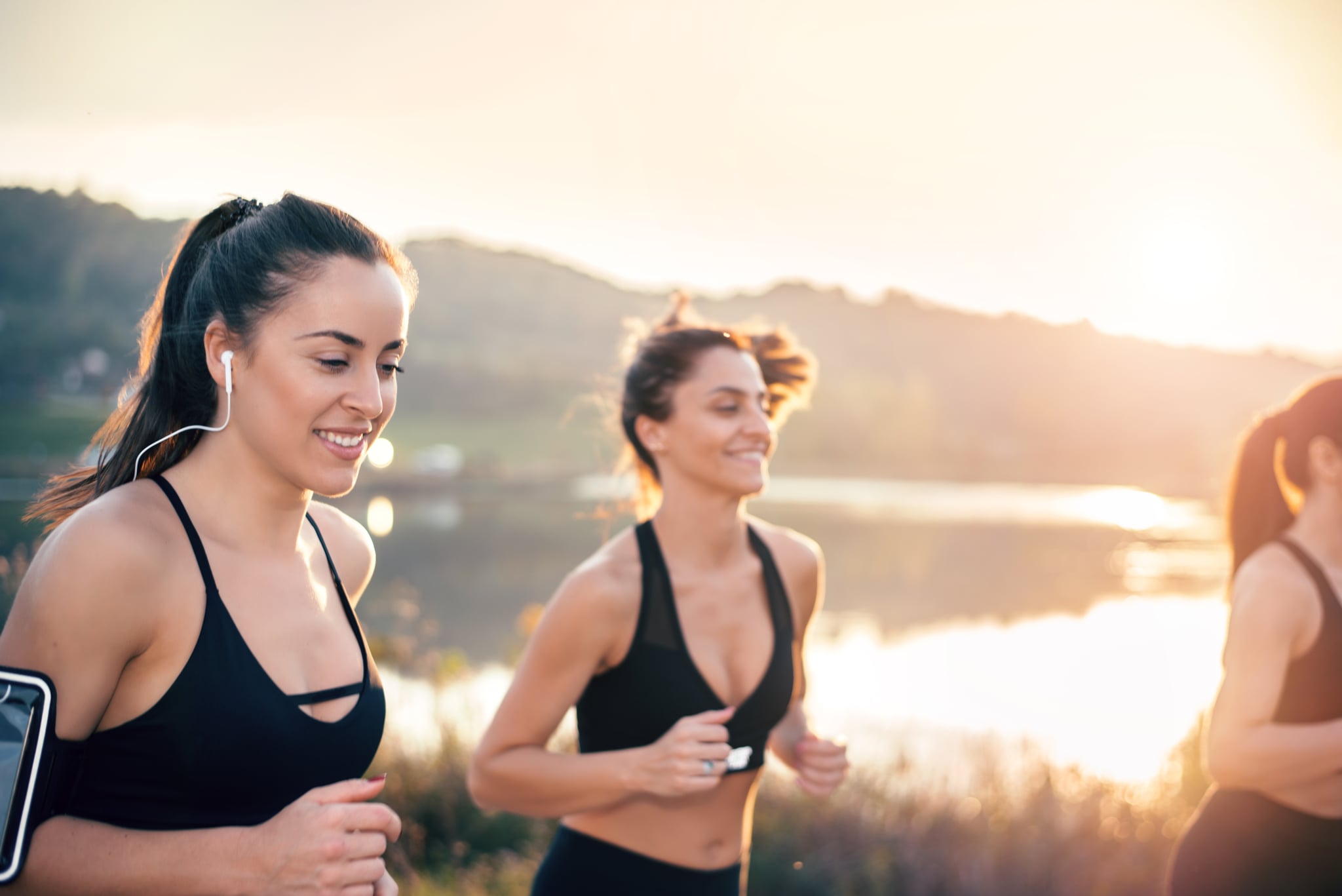 Young women running near lake