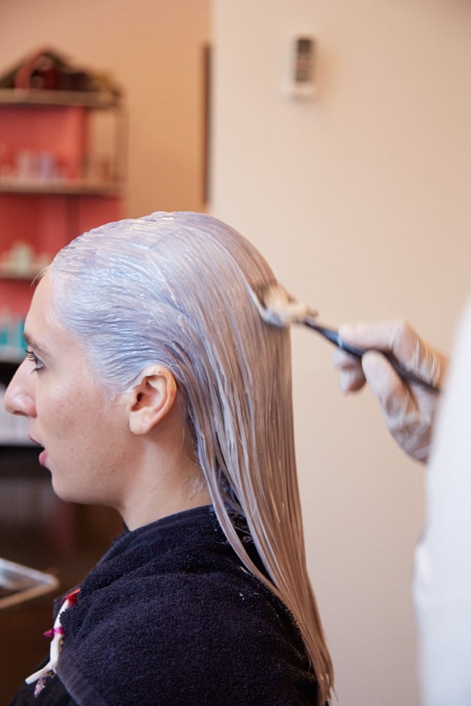 Here comes the denim! Jeanise painted on the next step of light blue toner. She applied it from the crown of my hair to halfway down my head. 
Jeanise said that if you're applying streaks of a funky shade rather than dying your entire hair one uniform color, it's smart to paint the hue on while your hair is in a middle part. 
Even if you're prone to side parting, putting the color on via the middle ensures versatility, because the application is symmetrical. That means no matter how you wear your hair, your color will look even and purposeful and won't imbalance your face.
This step actually uses a demi-permanent hair dye (as opposed to semi), so this will only last about eight washings.