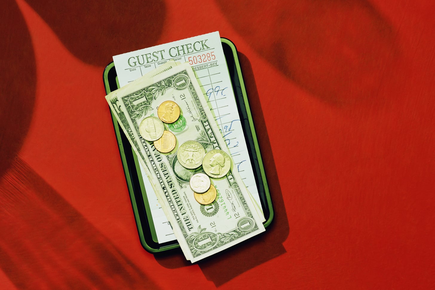 cash and coins on top of a restaurant bill