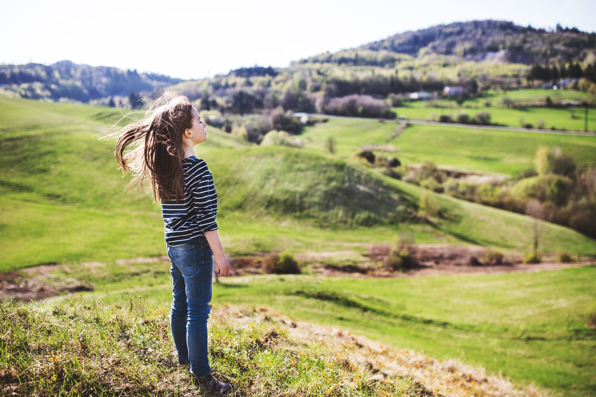 A small female child spending time outside. Rear view.