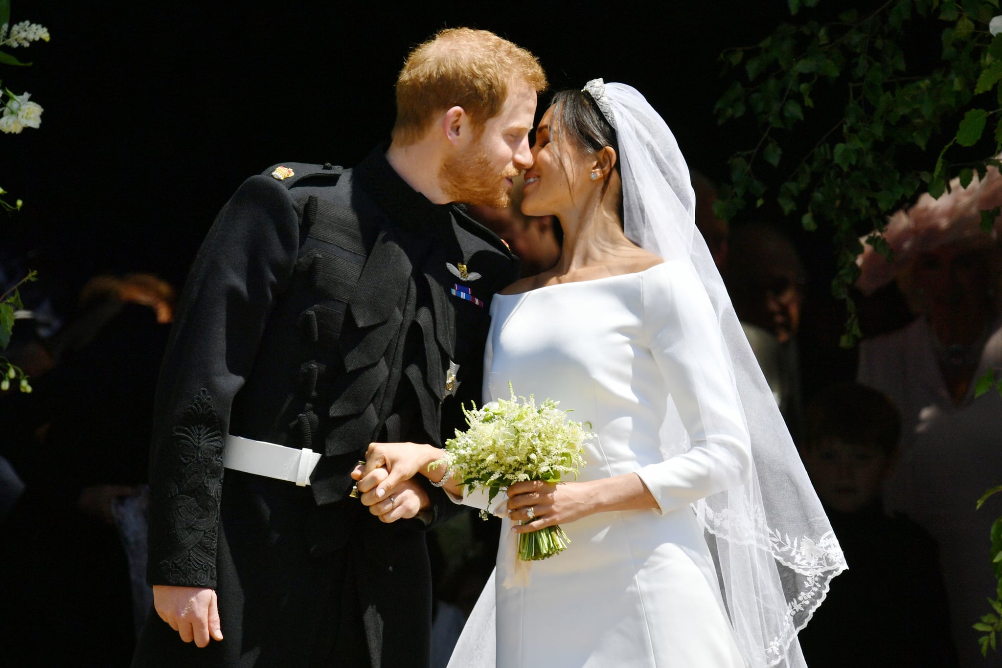 Britain's Prince Harry, Duke of Sussex kisses his wife Meghan, Duchess of Sussex as they leave from the West Door of St George's Chapel, Windsor Castle, in Windsor, on May 19, 2018 after their wedding ceremony. (Photo by Ben Birchall / POOL / AFP)        (Photo credit should read BEN BIRCHALL/AFP/Getty Images)