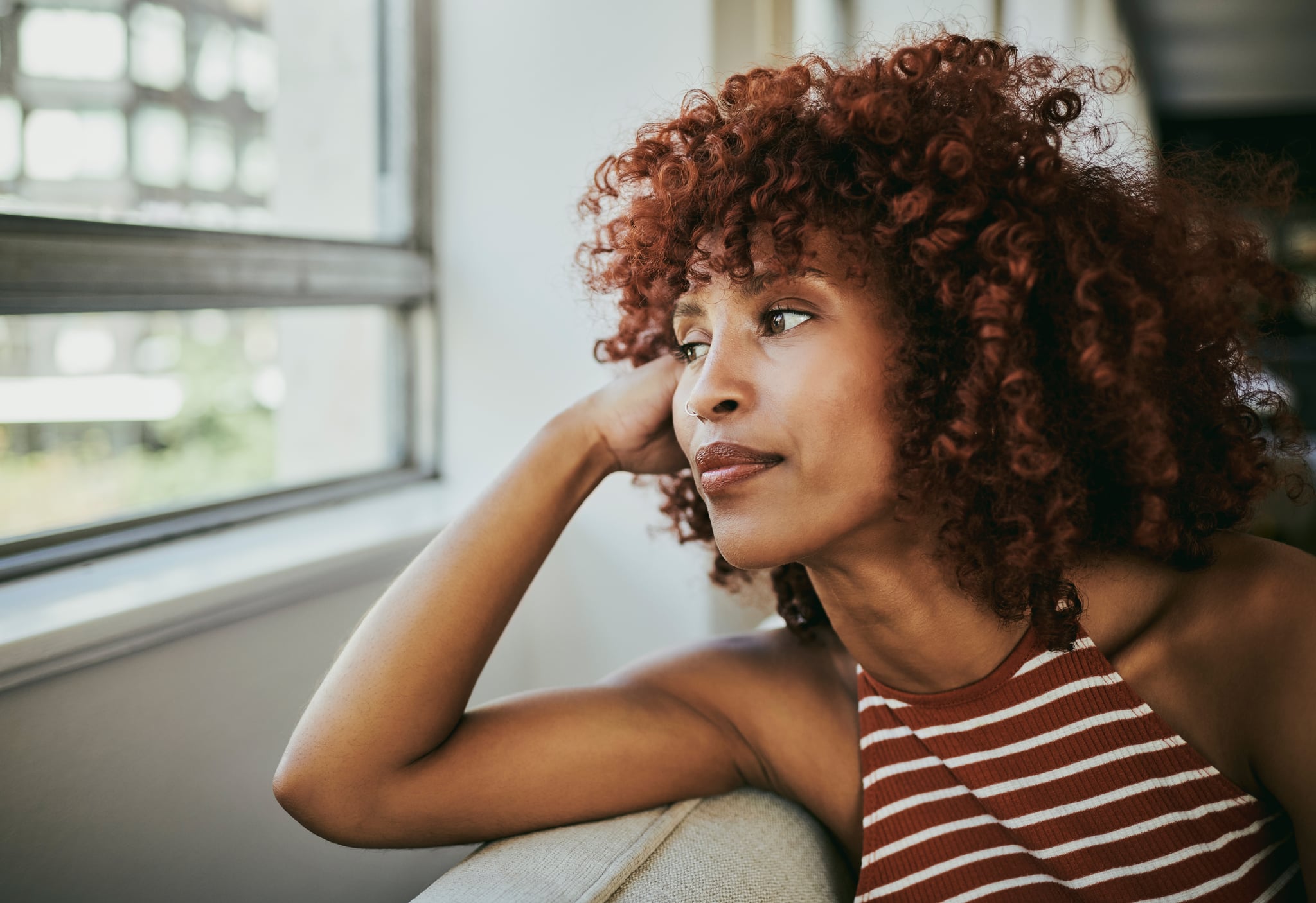 Woman on Sofa Looking Out the Window Pondering Life