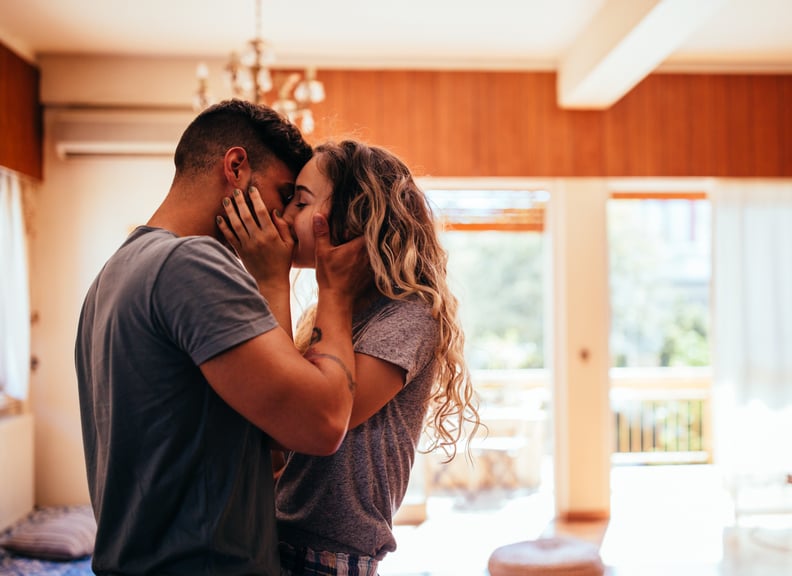 Romantic young hipster boyfriend and girlfriend relaxing at home and kissing with passion