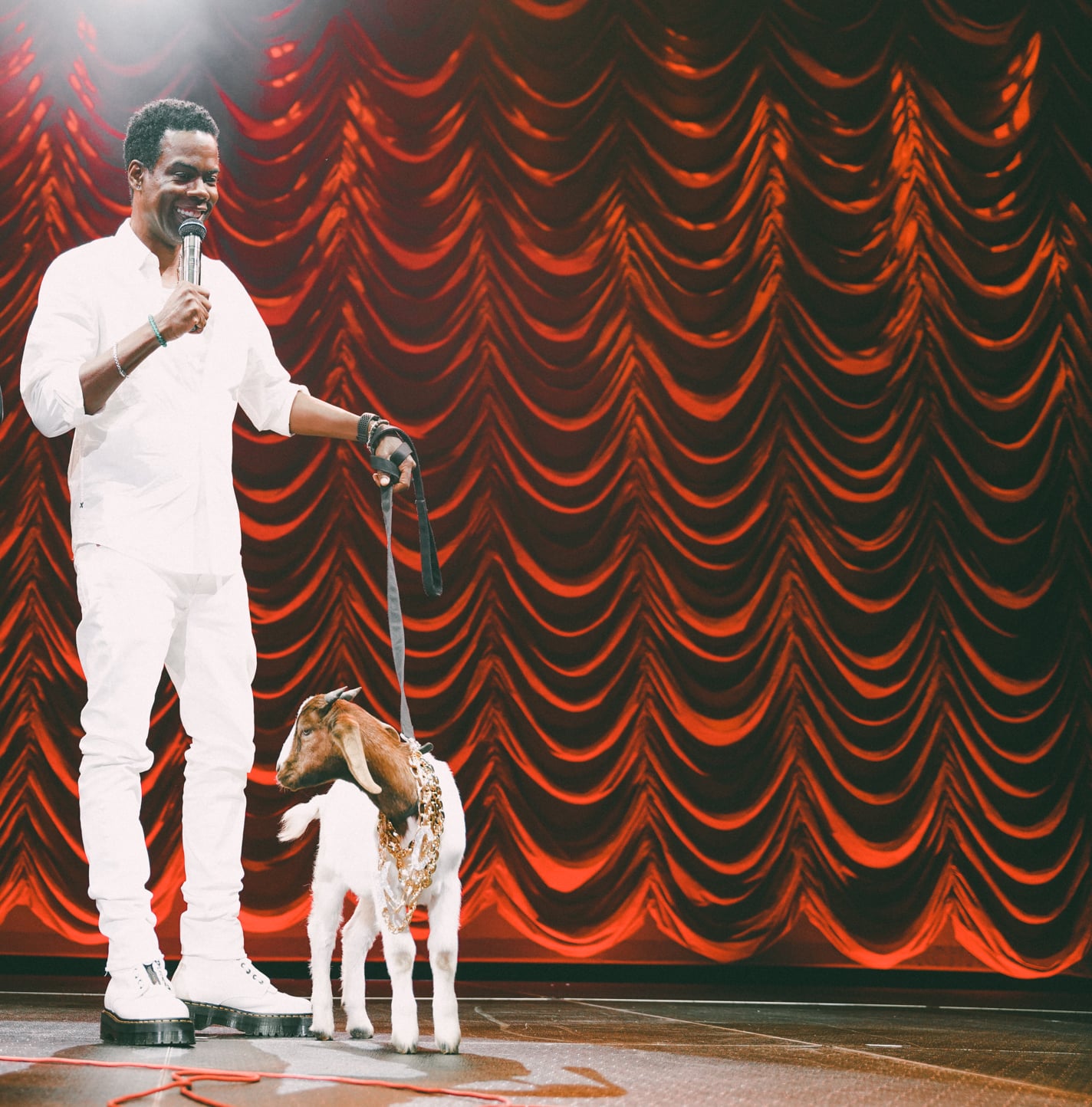 Chris Rock performing standup on stage.