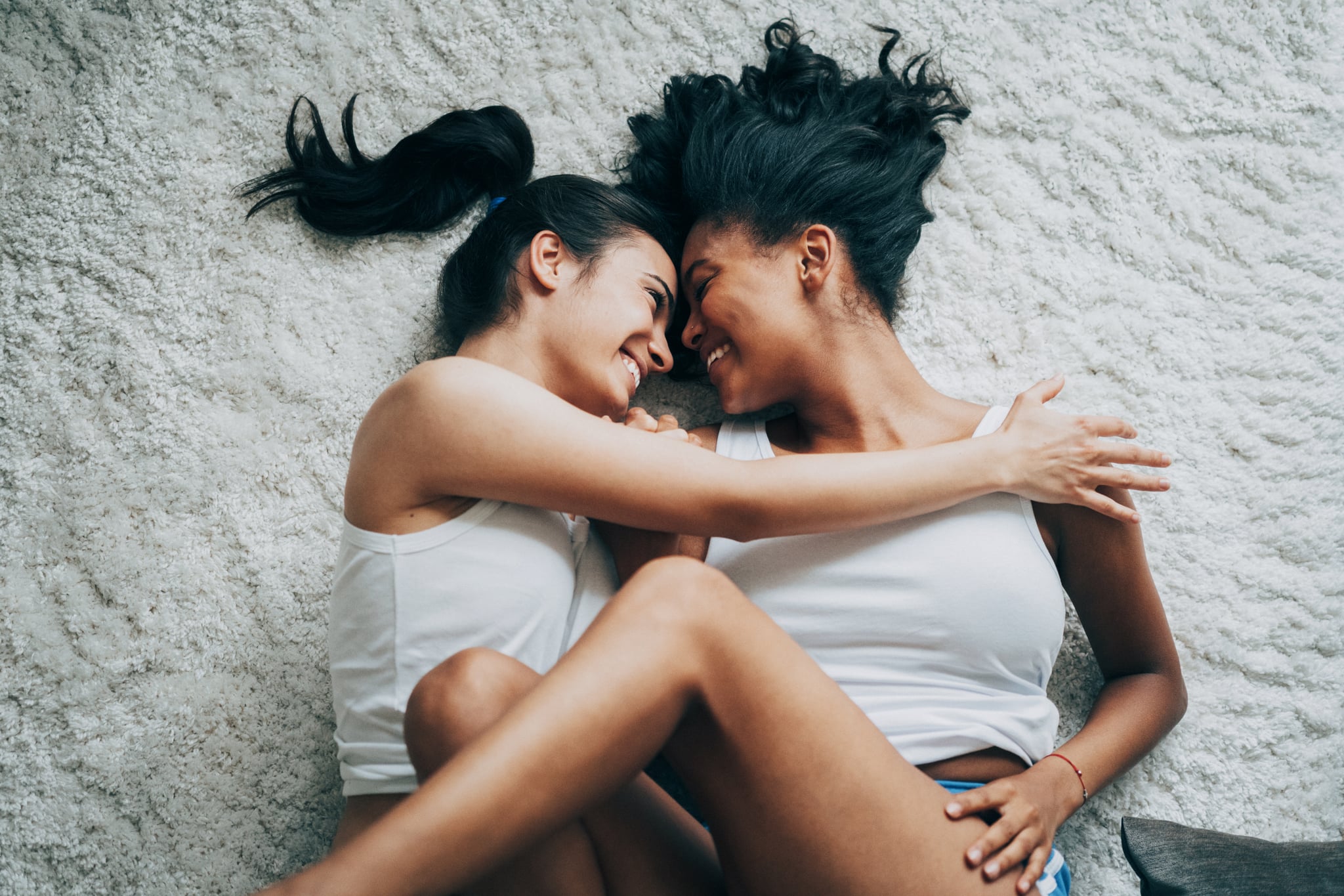 Two Women Laying Down In Intimate Embrace