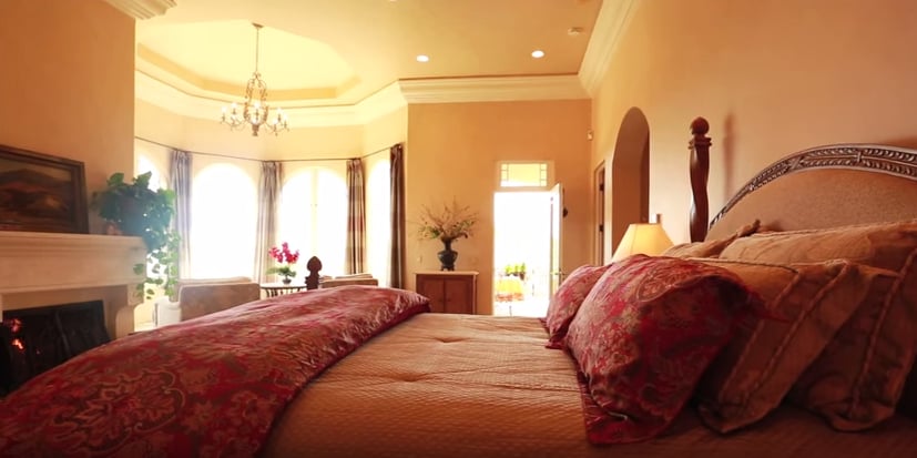 The luxurious bedroom is warm and inviting.