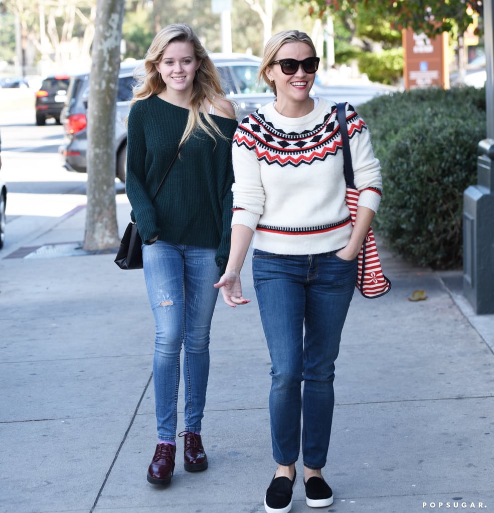 Reese wore skinny jeans with a Draper James sweater, and accessorized with the brand's printed Vanderbilt tote.