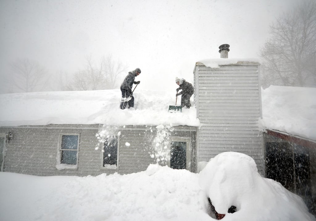 People in Buffalo, NY, shoveled snow from the roof of their house following a severe snowstorm.