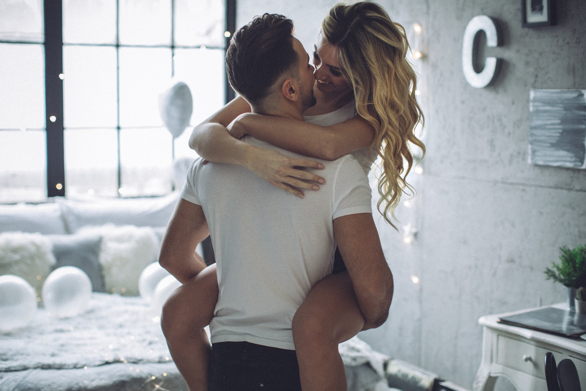 Couple on Valentine day enjoy in love. They are in bedroom and having romantic moment together