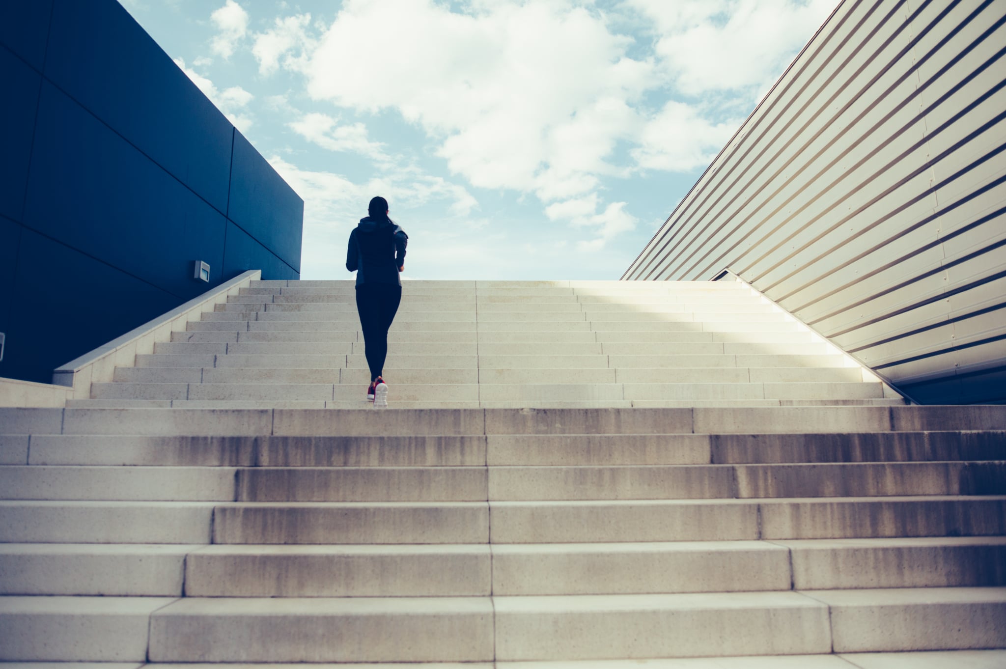 Woman exercising on a staircase outside in the city.