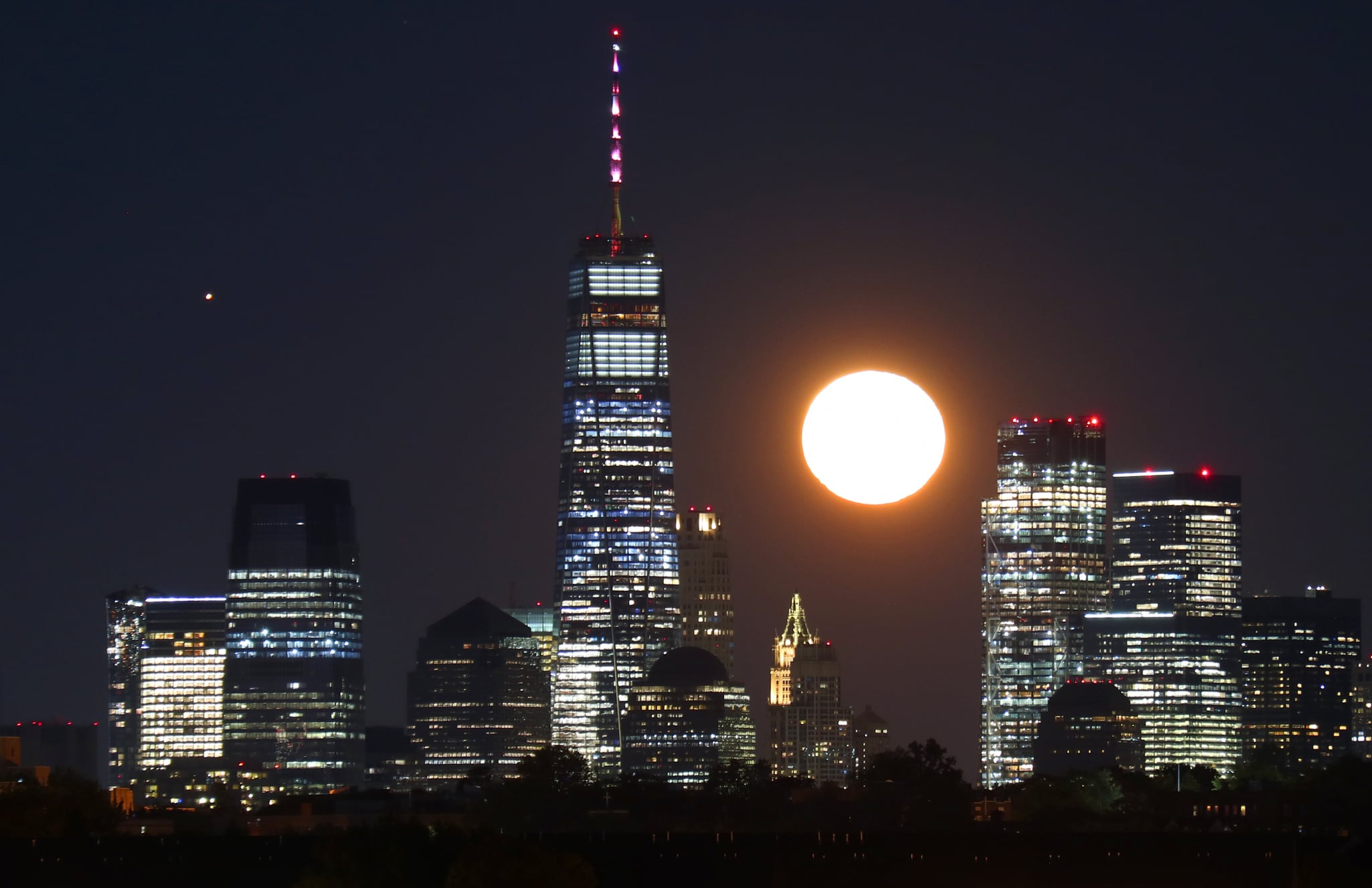 NEWARK, NJ - OCTOBER 2: The moon rises along with Mars behind lower Manhattan and One World Trade Center in New York City, a day after the full Harvest Moon on October 1, 2020 as seen from Newark, New Jersey. (Photo by Gary Hershorn/Getty Images)