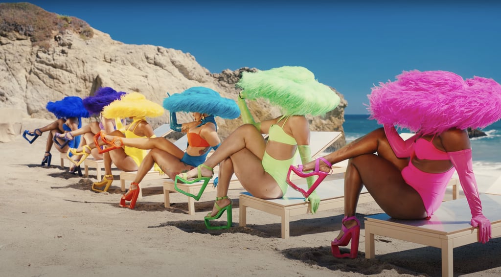 Cardi joins the dancers in coordinating LaQuan Smith one-pieces, opera gloves, cutout heels, and fuzzy hats.