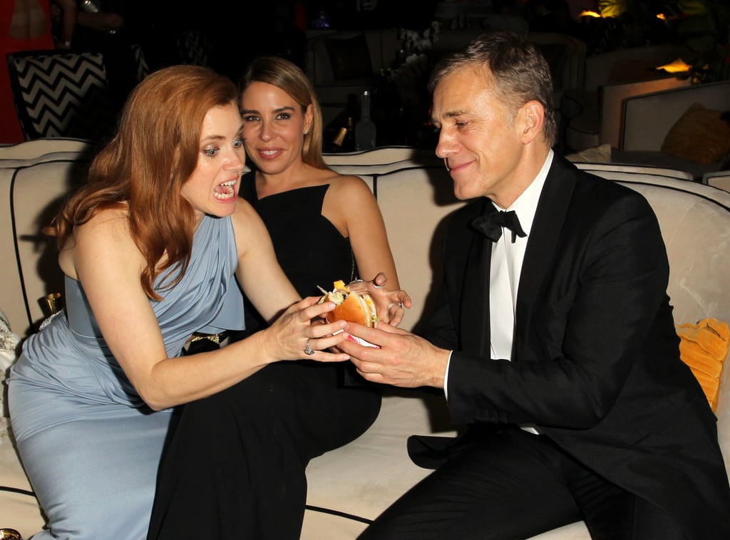 Amy Adams happily took a burger from Christoph Waltz during the Weinsten Company afterparty.